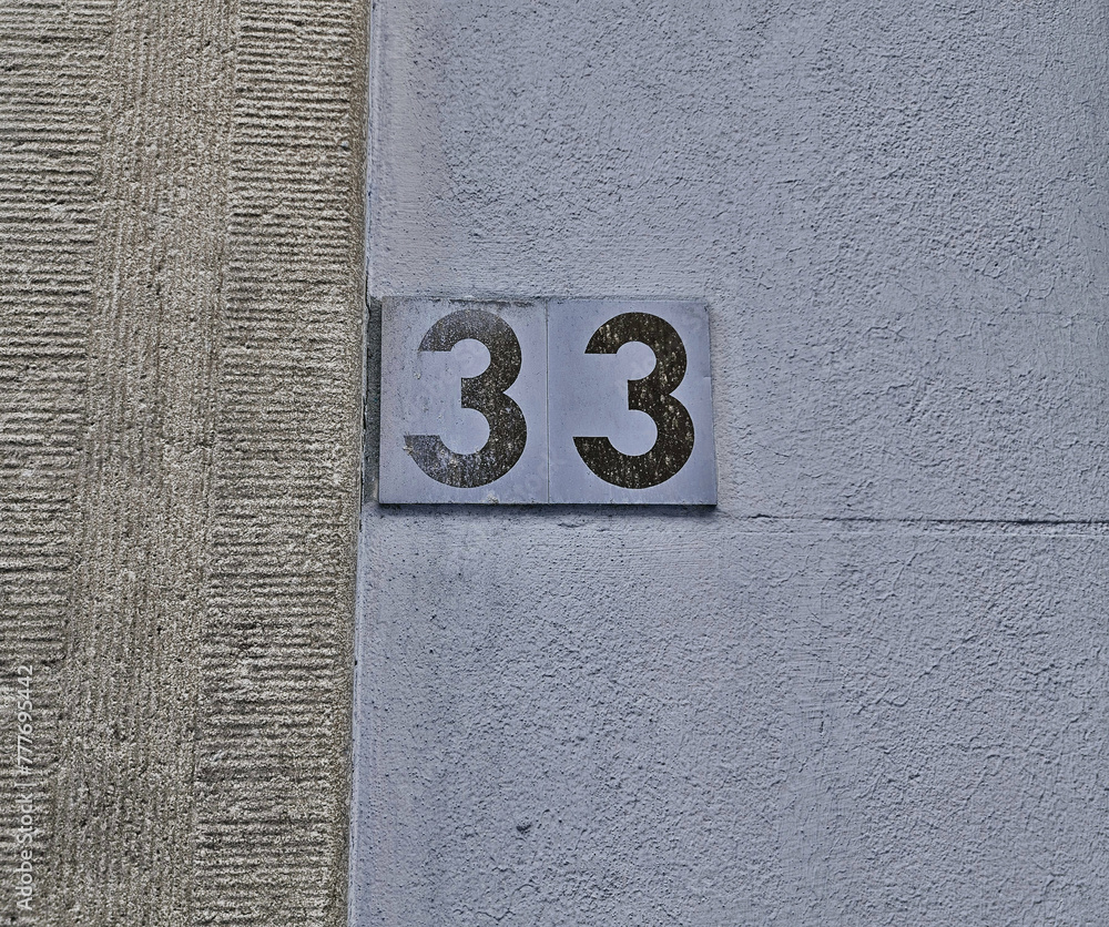 Number plate. Number thirty-three against wall background. Concept from - 33 Whitehall Street New York Ny